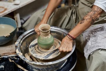 A talented woman focuses on crafting a stunning ceramic vase on a pottery wheel.