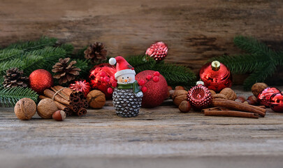 fir branches, Christmas balls, cones, cinnamon sticks, cute snowman figurine on wooden table. Christmas and new year holidays background. decorative composition for festive winter season