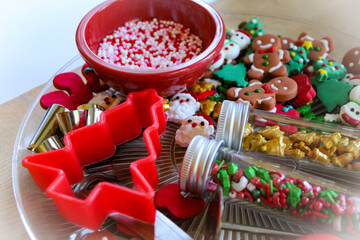 Close-up of Christmas holiday baking cupcake decorating sprinkles cookie supplies colorful shape red green confetti backdrop