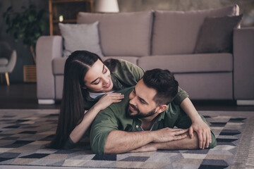 Photo of charming cheerful married guy lady wear casual shirts lying floor spending time together...
