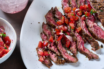 Skirt steak sliced on the plate with pico de gallo