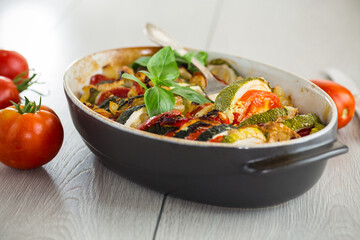 prepared baked zucchini and tomatoes in circles in a ceramic form, vegetable snack