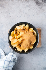 Sliced apples with brown sugar on skillet