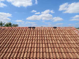 roof covered with terracotta tiles. The tiles are arranged in a uniform, overlapping pattern, creating a visually appealing and functional surface. The terracotta tiles are reddish-brown in color.