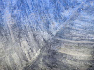 The surface appears to be textured with various lines and patterns, possibly indicating natural...