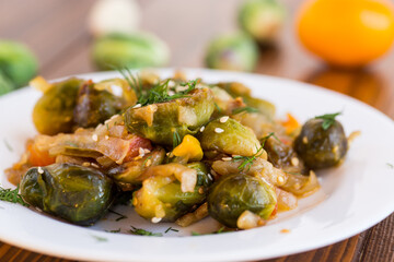 Brussel sprouts cooked with vegetables, on a wooden table