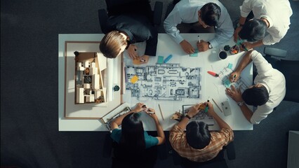 Top aerial view of project manager or civil engineer writing at blueprint and planning building design. Aerial view of architect working together at meeting table with document placed. Alimentation.