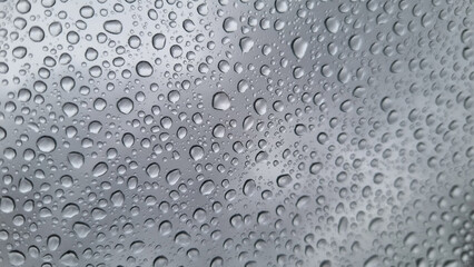 Raindrops on glass close-up. Black and white monochrome. Selective focus