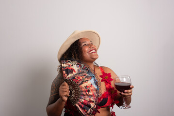 Woman wearing a gypsy hat and clothing holding a glass of wine and a fan. Isolated on white background.