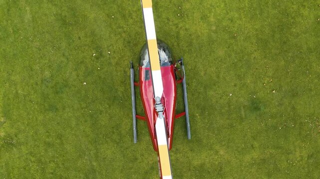 helicopter shutting down engines red blades rotors point upwards elegance aviation top birdseye aerial drone shot view footage propellers 
