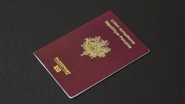 Passport of the Republic of France on a dark concrete background. Conceptual background on the theme of tourism and travel