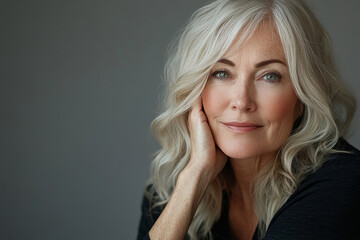 Naklejka premium Closeup portrait of a beautiful blond middle-aged mature woman looking at camera. Healthy face skin care beauty, middle age skincare cosmetics, cosmetology concept, anti-ageing care product. 