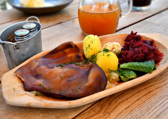Smoked pork ear served on rustic wooden plate in restaurant