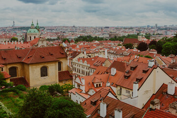 Fototapeta premium The skyline of Prague overlooks red rooftops of historic buildings. Discover the charm of Prague in Czech Republic - iconic landmarks, historic architecture, medieval styles and scenic views.