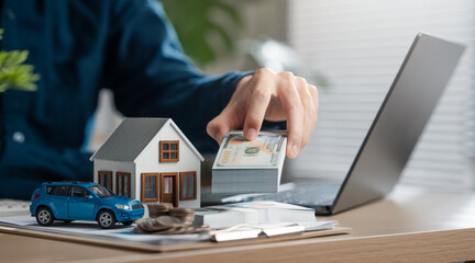 estate, insurance, property, real, real estate, residential, importance, finance, wealth, investment. A person is holding a stack of money in front of a house and a car.