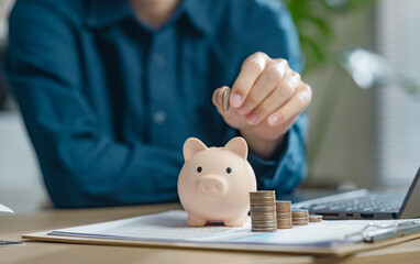 retirement, earnings, financial, loan, economic, finance, wealth, piggy bank, assurance, future. A person is putting coins into a piggy bank. Concept of saving money and being financially responsible.