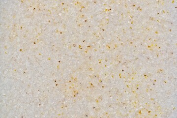White sand background detail textures yellow flecks grainy salt surface.	
