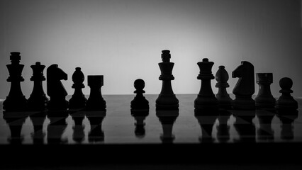 Chess pieces strategically placed on the chessboard symbolize power, vulnerability, and tactical...