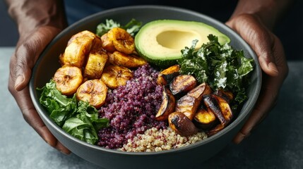 An African man crafts a fresh, delicious meal with quinoa, roasted veggies, plantains, and avocado