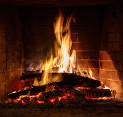 Fireplace burning, wood logs and bright flames. Warm home, heat. Christmas holiday