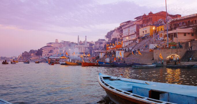 Varanasi, Uttar Pradesh, India. Many Boats moored on Ganga river near ghats. Hundreds of tourists and locals come in boats to watch Ganga Maha Aarti ceremony and the fire ceremony. Purple sunset sky