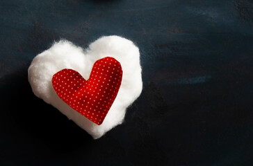 Fototapeta premium A cloudy white and red heart with dots on a dark background, symbolizing love and celebration.