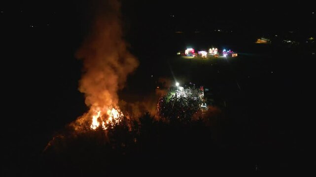 reveals crowd bonfire fair tain scotland smoke flames create scene families share laughter fun during nighttime backward aerial shot captivating festivities enjoyment vibrant atmosphere 