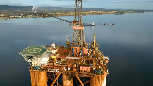 reveals offshore oil rig drilling platform parked estuary role energy production scene intersection engineering downward aerial panning footage view 