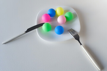 Plate with colored plastic balls instead of food.
Concept of plastic problem in the environment, food and daily life. Ecological and human health problem.