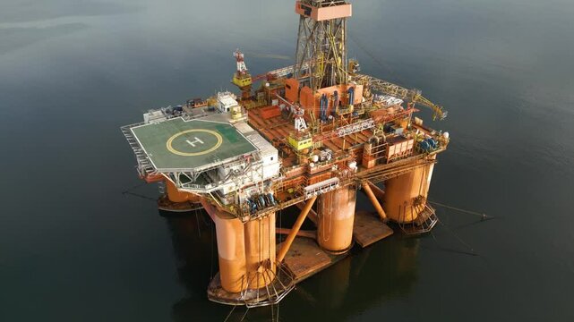 offshore oil rig drilling platform helipad above parked estuary scene platform's role energy production circling aerial footage view environmental context marine 