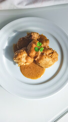 chicken with sauce on a white plate