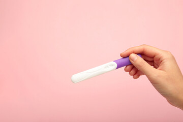 The new pregnancy test on pink background. Health care concept.
