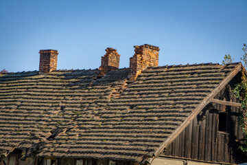 dilapidated old abandoned house in the city center. cracking brick chimneys on the roof. damaged...