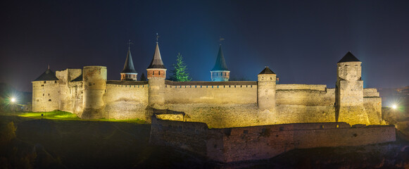 panorama of castle with towers illumination in night twilight 