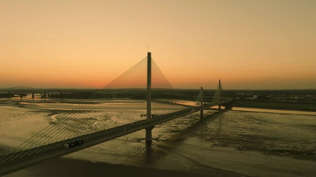 Liverpool, Merseyside, UK, September 18, 2024; aerial slide and orbit clip of the Mersey Gateway toll bridge with stunning sun set over the River Mersey, Liverpool, UK.