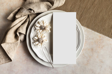 Blank menu card mockup and white flowers on plates top view, 4x9 wedding stationery card