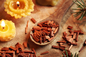 Red sandalwood chips on a spoon with beeswax candles