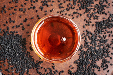 Black cumin or Nigella seed oil in a glass bowl, top view