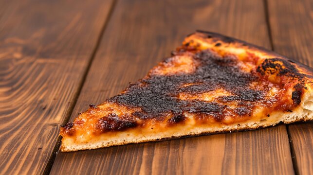 Pizza slice with overcooked cheese and crust on a rustic wooden table, illustrating a cooking error or kitchen blunder
