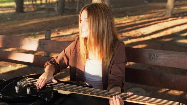 Happy Girl Playing Bass Instrument In The Park On The Table