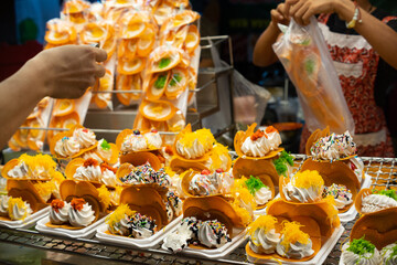 Thai Crispy Pancake. A table with many different types of food, including some with chocolate sauce. The table is set up for people to eat