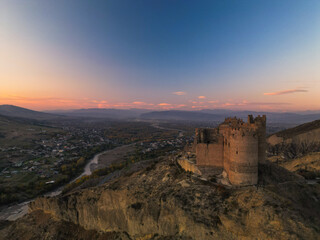 Obraz premium Fantasy breathtaking castle on top of mountain at sunset in Georgia Ksani