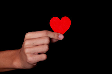 Fototapeta premium boy holding a red heart in his hand