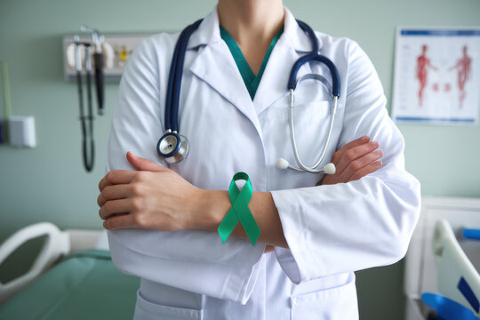 Doctor with a green ribbon on her white coat folds arms confidently, promoting mental health awareness in a clinical setting, emphasizing professional commitment to wellbeing