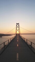 Obraz premium A beautiful bridge stretching towards the horizon as the sun sets in the background, creating a breathtaking view of endless possibilities, yellow, infinitive
