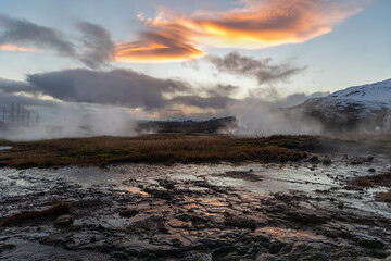 Thermal landscape at sunset with reflection on the steaming ground at Strokkur Geyser, Iceland