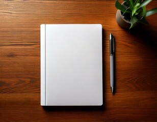 Book cover mockup blank white notebook lying down on a brown wood table with green house plant cactus and a pen top down overhead view, graphic design resource 