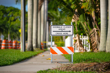 Warning sign that sidewalk is closed at street construction site. Utility work ahead