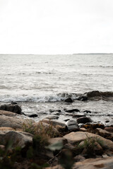 A tranquil view of a rocky shoreline as gentle waves meet the coast. This scene emphasizes natural beauty and the serenity of coastal landscapes, ideal for themes of nature and solitude.