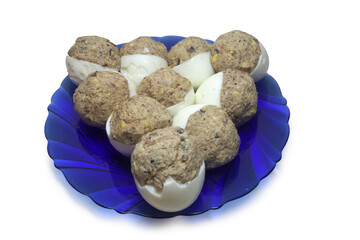 stuffed egg halves, arranged in triangle shape, on glass semitransparent blue plate. isolated on...